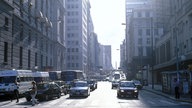 Befahrene Avenida Corrientes mit Häuserzeilen rechts und links.