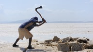 Ein Afar-Nomade, der auf dem Salzsee das weiße Gold abbaut.