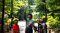 Kinder mit einem Förster im Wald