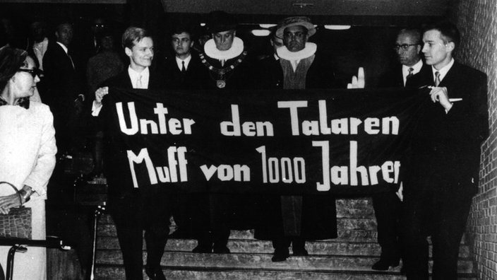 Studenten mit einem Spruchband: Unter den Talaren Muff von 1000 Jahren beim Eintritt des neuen und des alten Rektors der Universität Hamburg ins Auditorium Maximum.