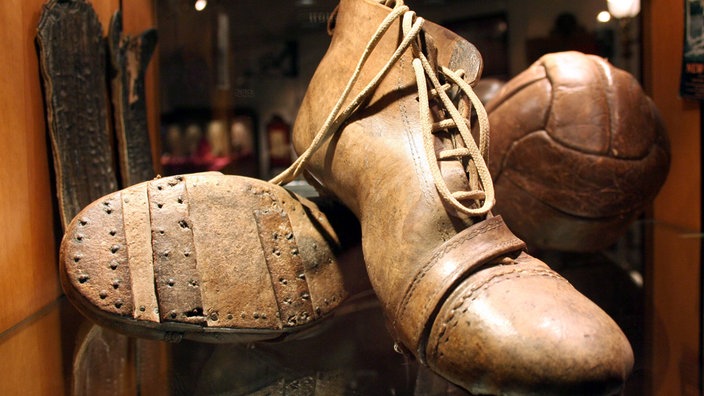 Ein Paar alte Fußballschuhe in einem Museum