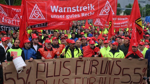 Demonstration von Gewerkschaftern der IG Metall. Auf Transparenten steht "Warnstreik, unser gutes Recht" und "5,5 % Plus für uns alle"