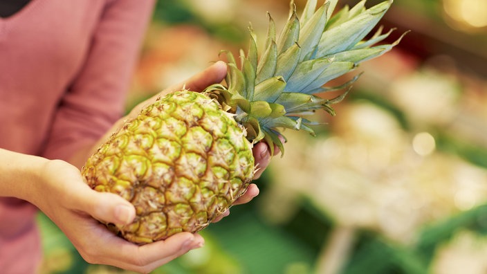 Frau hält eine Ananas