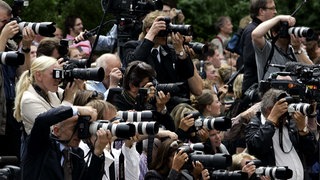 Mehrere Paparazzi mit Kameras.