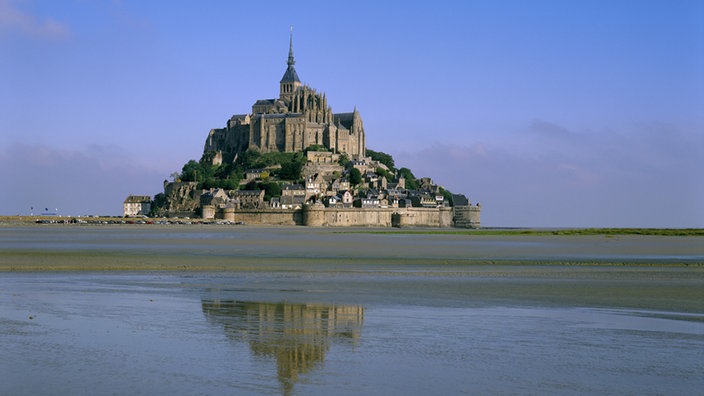 Blick über ein Wattenmeer auf den französischen Klosterberg Mont St. Michel.