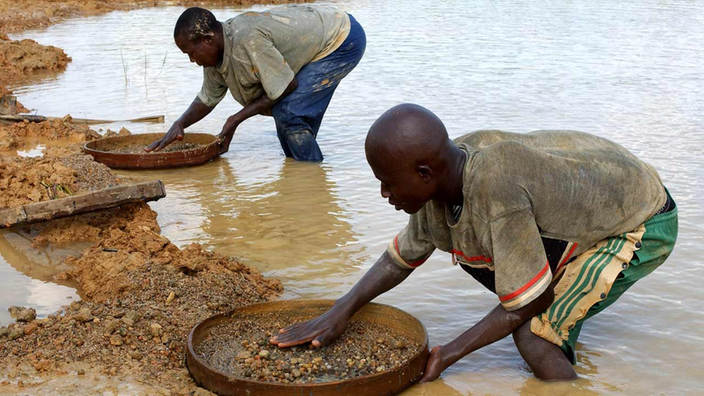 Zwei Arbeiter stehen im Fluss und sieben Sand nach Rohdiamanten.