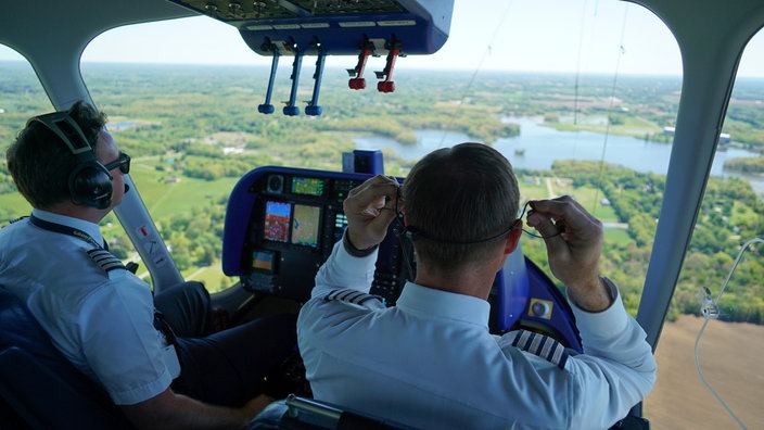 Zwei Piloten sitzen im Cockpit eines Blimps